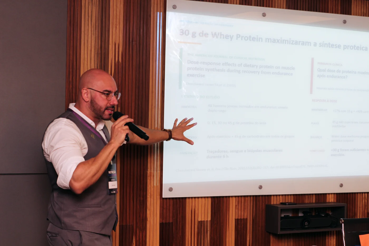 Caíque Turano explicando uma apresentação sobre nutrição