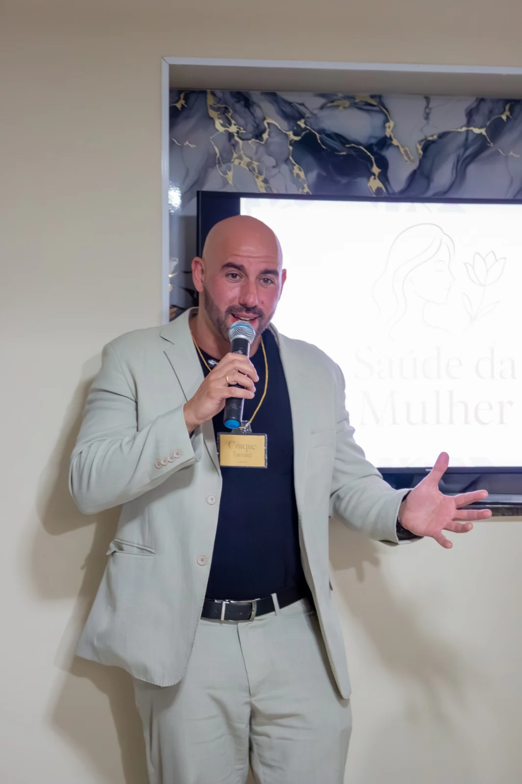 Caíque Turano com microfone em apresentação